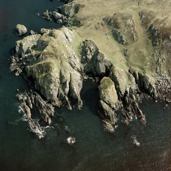 Oblique aerial view centred on the remains of Dun Mor Ghil fort, The OA, Islay, taken from the SW.