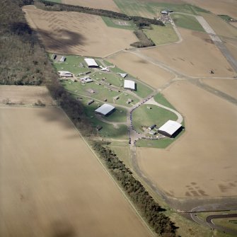 Oblique aerial view of East Fortune Airfield centred on the aircraft hangers, taken from the ENE.