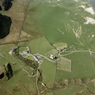 Oblique aerial view of Kilchoman centred on the church, burial-grounds and manse, taken from the NE.