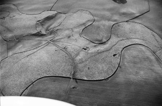 Oblique aerial view of the remains of the earthwork and pit-alignment, taken from the E.