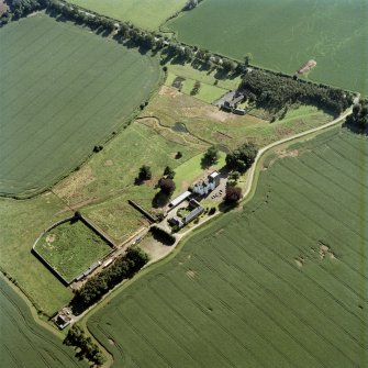 Oblique aerial view centred on the tower house, with the coach house, stable and walled garden adjacent, taken from the NNE.