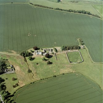 Oblique aerial view centred on the tower house, with the coach house, stable and walled garden adjacent, taken from the S.
