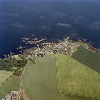 Oblique aerial view centred on the village, with the harbour adjacent, taken from the W.