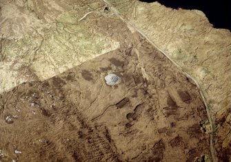 Oblique aerial view centred on the remains of the chambered cairn, taken from the SE.