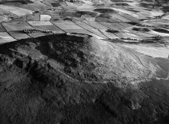 Oblique aerial view centred on the remains of the vitrified fort at Tap O' Noth, looking to the SW.