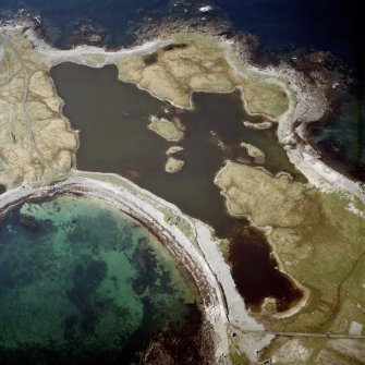Oblique aerial view centred on the remains of the dun, taken from the SE.