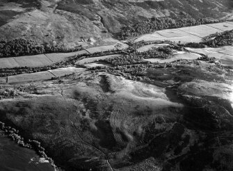 Oblique aerial view centred the remains of a field system and hut circles at Burn of Holmhead, lloking to the NE.