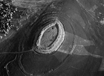 Oblique aerial view centred on the cropmarks of roundhouses  and a rectangular enclosure within the White Caterthun fort, looking to the SSW.