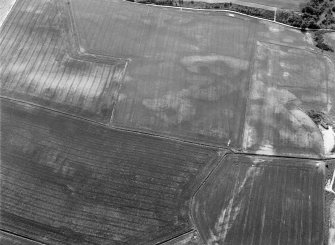 Oblique aerial view centred on the cropmarks of the unenclosed settlement, ring ditch, souterrains and pits at Burnhead of Monboddo, looking to the SSE.