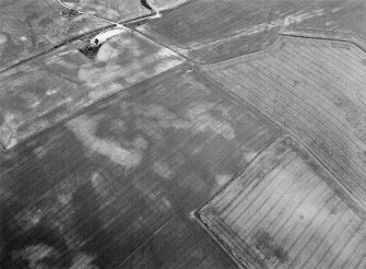 Oblique aerial view centred on the cropmarks of the unenclosed settlement, ring ditch, souterrains and pits at Burnhead of Monboddo, looking to the NW.