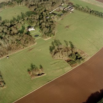 Scanned image of oblique aerial view centred on the deserted medieval village, bastle, church and burial ground, with remains of the rig, possible enclosures, country house and walled garden adjacent, taken from the SW.