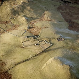 Scanned image of oblique aerial view centred on the remains of the farmstead, buildings and tower-house, with the remains of the farmstead adjacent, taken from the SSE.