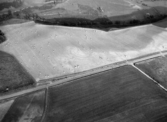 Oblique aerial view centred on the cropmarks of the circular enclosure at Barflat, looking to the SE.