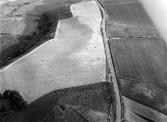 Oblique aerial view centred on the cropmarks of the circular enclosure at Barflat, looking to the SSW.