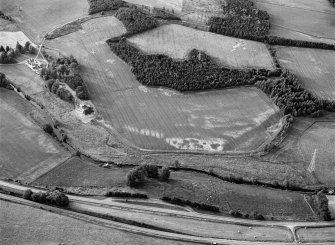 Oblique aerial view centred on cropmarks of the unenclosed settlement, roundhouses and rig at Logie House, looking to the NNW.