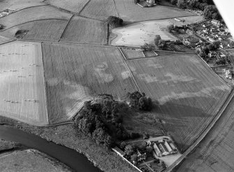 Oblique aerial view centred on the cropmarks of the barrow at Boat of Hatton with the burial ground adjacent, looking to the N.