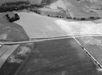 Oblique aerial view centred on the cropmarks of the circular enclosure at Barflat with the cropmarks of the possible square barrows adjacent, looking to the ESE.

