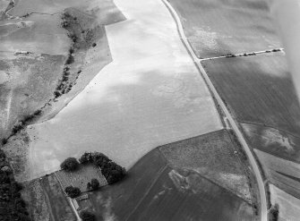 Oblique aerial view centred on the cropmarks of the circular enclosure at Barflat with the cropmarks of the possible square barrows adjacent, looking to the S.

