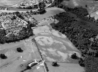 Oblique aerial view centred on the cropmarks of the palisaded enclosure, linear features, pits and rig at Heogan and East Mains of Aboyne, looking to the SSW.

