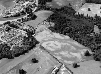 Oblique aerial view centred on the cropmarks of the palisaded enclosure, linear features, pits and rig at Heogan and East Mains of Aboyne, looking to the SSW.

