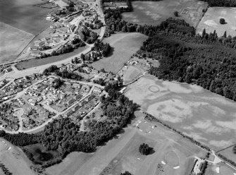 Oblique aerial view centred on the cropmarks of the palisaded enclosure, linear features, pits and rig at Heogan and East Mains of Aboyne, looking to the SW.

