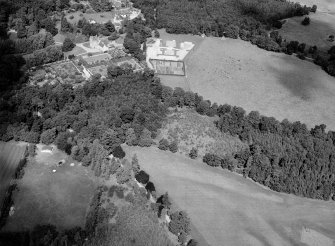 Oblique aerial view centred on the cropmarks of the pit alignment and timber hall with Crathes Castle and gardens adjacent, looking to the NW.

