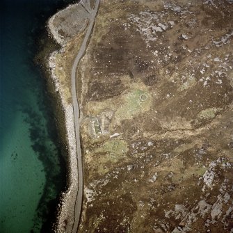 Oblique aerial view centred on the remains of the wheelhouse and blackhouse with the remains of the building and hut-circle adjacent, taken from the ENE.