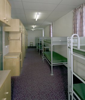 Interior view of 1935 Barrack Block showing ground floor dormitory with bunk beds and storage cupboards from S.