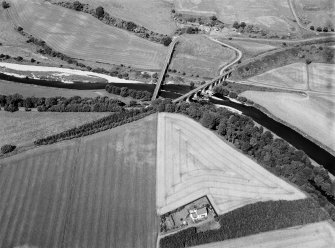 Oblique aerial view centred on the cropmarks of the palisaded enclosure at Fisherhills with the North Water viaduct adjacent, looking to the WNW.