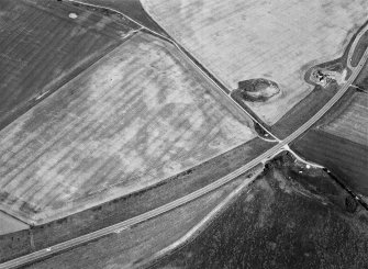 Oblique aerial view centred on the cropmarks of the pit defined cursus and linear features at Purlieknowe, looking to the N.
