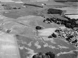 Oblique aerial view centred on the cropmarks of the barrow at Boat of Hatton with the burial ground and Hatton of Fintray adjacent, looking to the NNE.