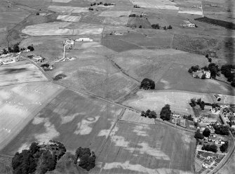 Oblique aerial view centred on the cropmarks of the barrow, rig and pits at Boat of Hatton with the burial ground adjacent, looking to the NNW.