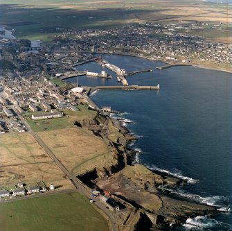 General oblique aerial view centred on the harbour and the town, taken from the E.