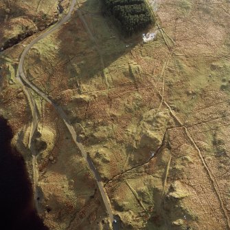 Oblique aerial view centred on the remains of the military camp, taken from the NNE.