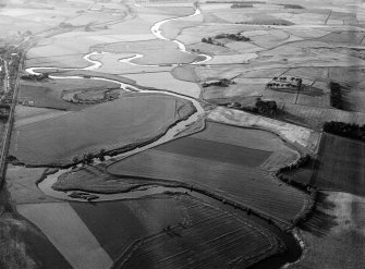 General oblique aerial view centred on the cropmarks of a palisaded enclosure, ring ditches, field system and pits at Wester Fintray, looking to the NW.