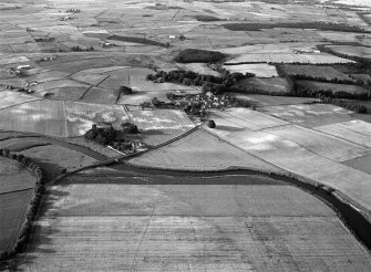 General oblique aerial view centred on the cropmarks of the barrow at Boat of Hatton with the burial ground and Hatton Bridge adjacent, looking to the NNE.