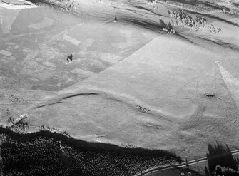 Oblique aerial view centred on the remains of ring ditch houses at White Caterthun, looking to the E.