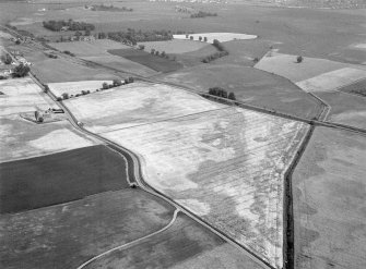 Oblique aerial view centred on the cropmarks of the unenclosed settlement and pits at West Mains of Hedderwick, looking to the ESE.