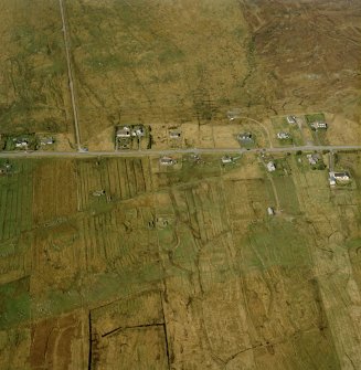 Oblique aerial view centred on the township, the remains of the buildings, the school and church, taken from the SSW.