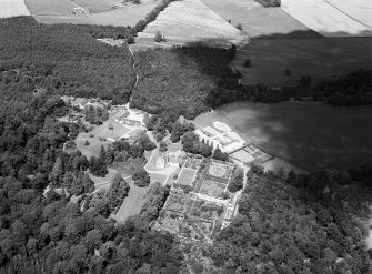 Oblique aerial view centred on Crathes Castle and gardens with the cropmarks of the pit alignment and timber hall adjacent, looking to the NNE.