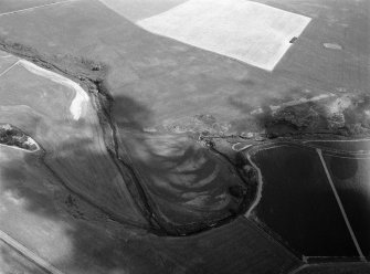 Oblique aerial view centred on the remains of a pit alignment, rig and enclosures at Corbie's Pot with a possible souterrain at Mill of Mondynes adjacent, looking to the ENE.