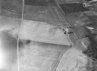 Oblique aerial view centred on the cropmarks of a circular enclosure at Myreside with the farmstead adjacent, looking to the ENE.