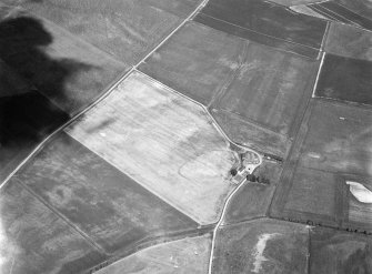 Oblique aerial view centred on the cropmarks of a circular enclosure at Myreside with the farmstead adjacent, looking to the ENE.