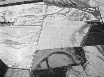 General oblique aerial view centred on the cropmarks of the unenclosed settlement, ring ditches, souterrains, field boundaries and rig at Westside, looking to the ENE.