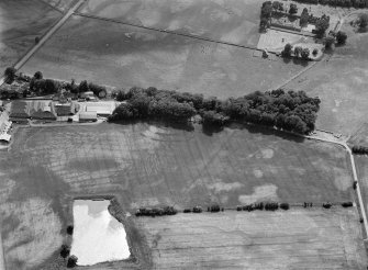 Oblique aerial view centred on the cropmarks of the fort, ring ditch and rig at Mains of Edzell with the farmstead adjacent, looking to the WSW.