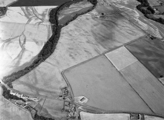Oblique aerial view centred on the cropmarks of the pit defined cursus, unenclosed settlement, ring ditches, enclosures, pits and rig with Stracathro Roman Fort and Temporary Camp adjacent at Inchbare North, looking to the ENE.