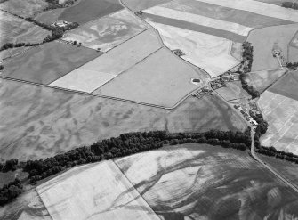 Oblique aerial view centred on the cropmarks of the unenclosed settlement, ring ditches, pits and rig with Stracathro Roman Fort and Temporary Camp adjacent at Smiddyhill, looking to the S.