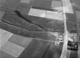 Oblique aerial view centred on the cropmarks of a rectlinear enclosure, possible souterrains, pits and rig at Chapel Knap, looking to the SSE.