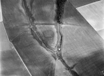 Oblique aerial view centred on the cropmarks of a rectlinear enclosure, possible souterrains, pits and rig at Chapel Knap, looking to the SE.