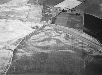 Oblique aerial view centred on the cropmarks of the pit defined cursus and linear features at Purlieknowe, looking to the E.